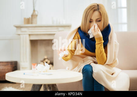 Blond woman feeling bad and having runny nose Stock Photo