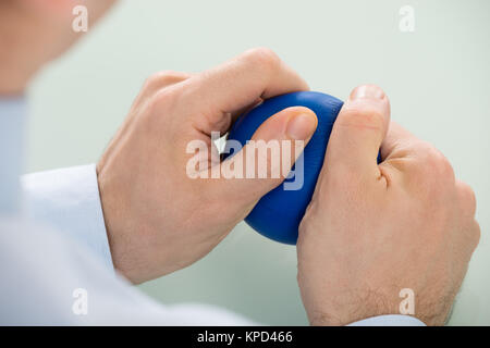 Businessperson Pressing Stressball In Hand Stock Photo