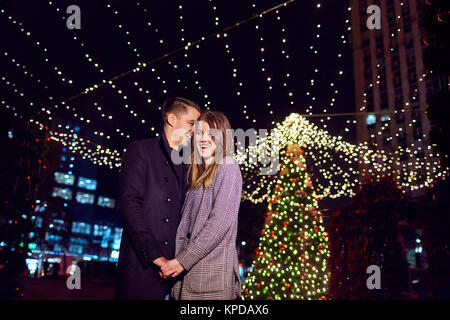 Loving couple embracing smiling at night on the background of Ch Stock Photo