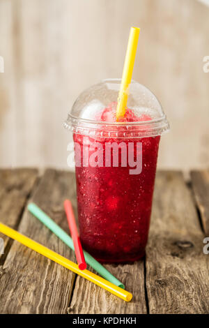 frozen red slushie in plastic cup with straw Stock Photo