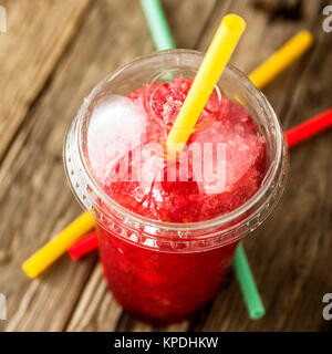 frozen red slushie in plastic cup with straw Stock Photo