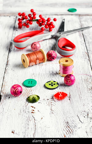 Thread,buttons,beads and scissors on the table light vintage Stock Photo