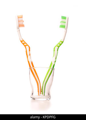 Colorful tooth brushes in a glass on white Stock Photo