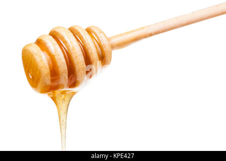 clear honey flows down from wooden stick isolated Stock Photo