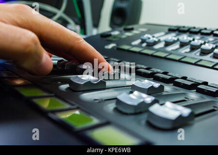 hand on a light, mixing desk fader in blur television gallery Stock Photo