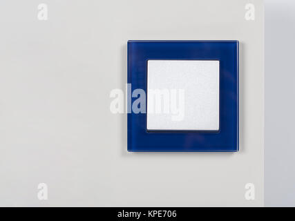 light switch with blue glass frame on the wall Stock Photo