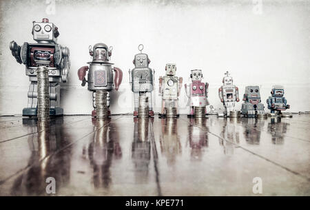 A line of retro toys with staks of gold coines on a wooden floor concept equality Stock Photo