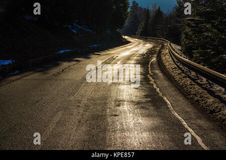 A shiny road curve in the Vosges mountains in winter, France. Stock Photo