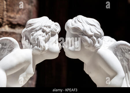 white plaster figurines kissing cupids, close up Stock Photo