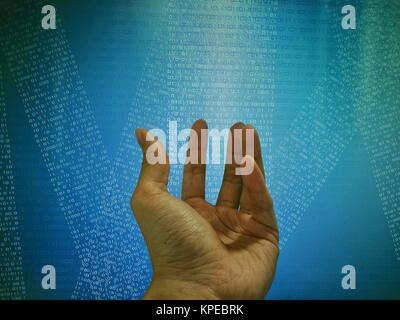 Hand in front of coding on computer screen display. Blue binary code background. Stock Photo