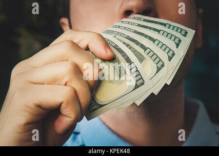 Handsome young businessman holding and smelling money. the smell of money. 500 dollars Stock Photo