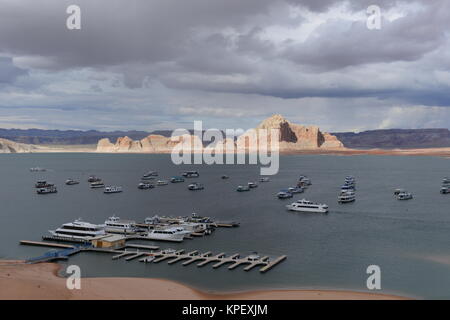 Wahweap Bay of Lake Powell - Stormy spring day, houseboats, tour boats, and luxury yachts are scattered in Wahweap Bay of Lake Powell. Stock Photo