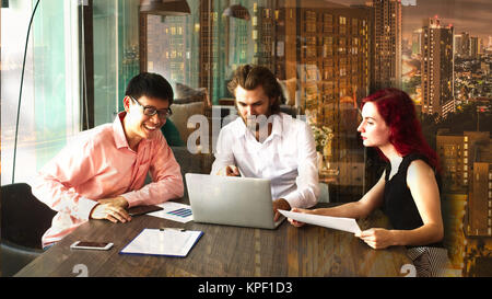 Team of young business people are working happily on project in front of big city scene showing options Stock Photo