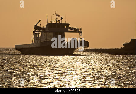 NC01063-00...NORTH CAROLINA - The Cedar Island - Ocracoke ferry arriving at the Silver Lake Harbor at sunset. Stock Photo