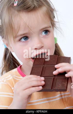 Kleines Maedchen isst eine Tafel Schokolade - child eats chocolate