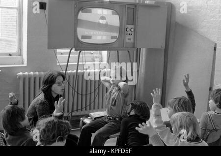 Primary school children 1970s England watching television in classroom with their teacher. 70s UK HOMER SYKES