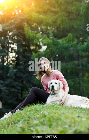 Image from below of woman sitting with dog on green lawn Stock Photo