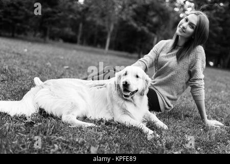 Black and white photo of brunette hugging labrador Stock Photo