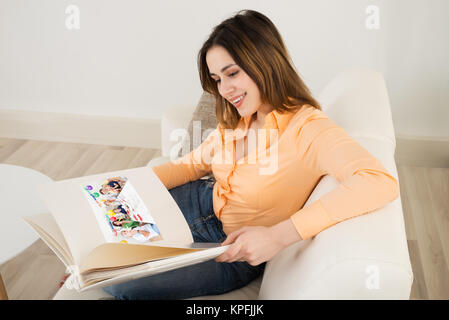 Happy Woman Looking At Photo Album Stock Photo