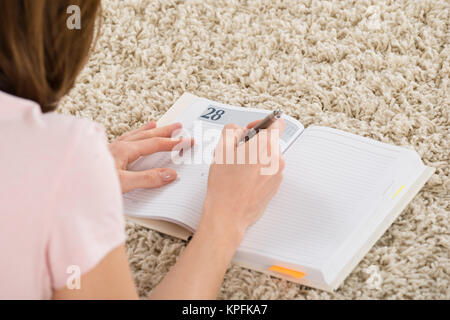 Woman Writing Schedule In Her Diary Stock Photo