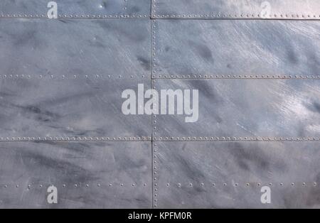 Airplane fuselage silver metal texture with rivets. Useful as background for design works. Stock Photo