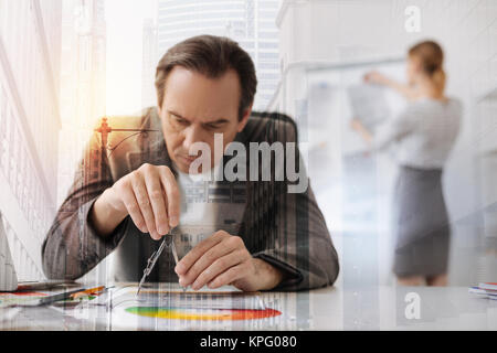 Professional concentrated male engineer using compasses Stock Photo
