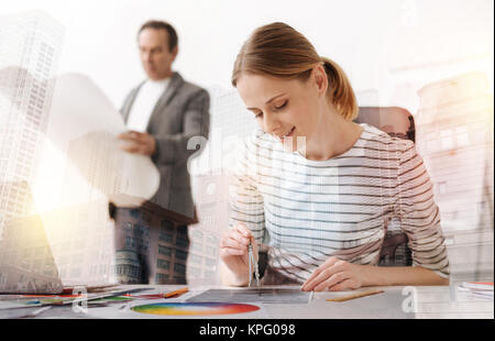 Attractive female engineer using compasses in her work Stock Photo