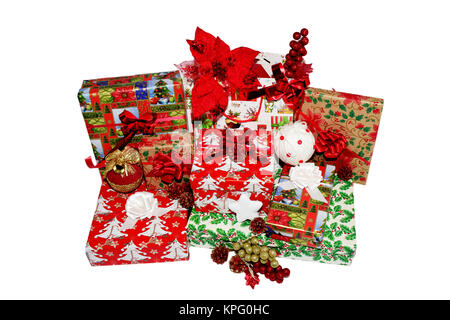 Christmas gifts in boxes and bags, wrapped in themed paper. Decorations with red decorative flowers, Christmas white and golden globes and pine cones Stock Photo