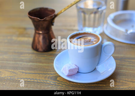 Turkish coffee served with a coffee pot on a wooden table Stock Photo