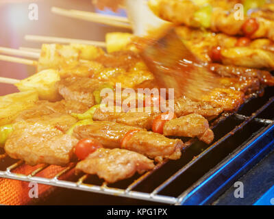 Thai street vendor sells pork satay - bbq fried pork meat on sticks. Stock Photo