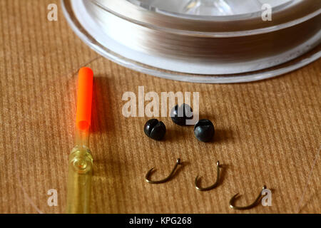 Close up of freshwater fishing tackle comprising of monofilament line, split shot weights, barbless fishing hooks and waggler fishing float Stock Photo