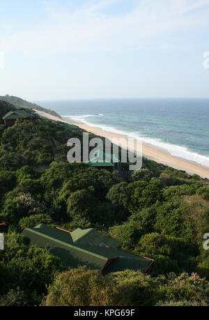 Mozambique, holiday resort cottages in thick vegetation with a view of the ocean in Ponta Do Ouro Stock Photo