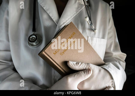 Doctor holds in a Munchausen syndrome book in a hospital. Conceptual image Stock Photo