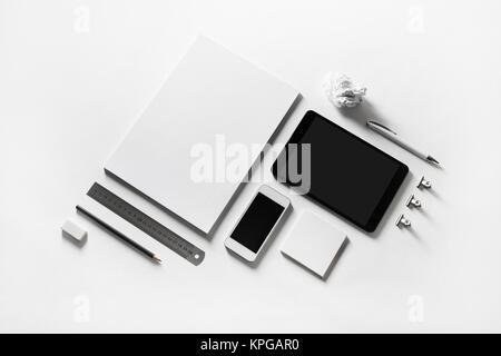 Blank stationery and gadgets at white paper background. Stock Photo