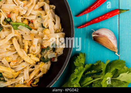 Thai Style Chicken Pad Thai With Noodles On A Blue Wooden Background Stock Photo