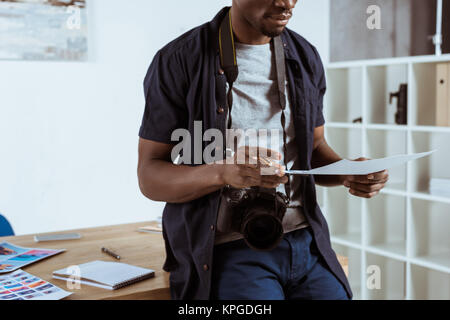 cropped shot of african american photographer with photoshoot examples Stock Photo
