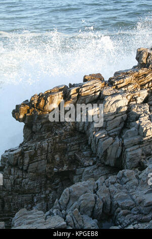 Wave breaking over rocks, Splash Rock, Hermanus, South Africa Stock Photo