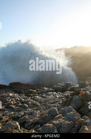 Wave breaking over rocks, Splash Rock, Hermanus, South Africa Stock Photo