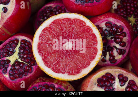 pile of fresh grapefruits on pomegranates background Stock Photo