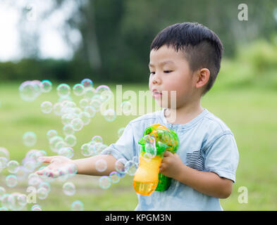 Young boy play with bubble gun and touch on the bubble Stock Photo