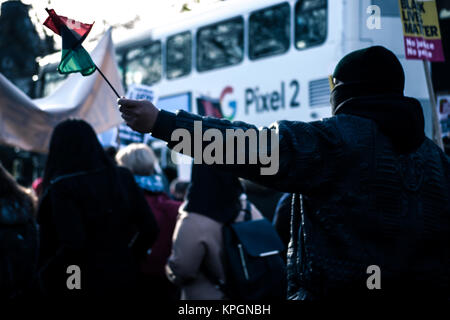 A protester seen holding a Libyan flag during the demonstration. In response to the slave trade in Libya, African Lives Matter held a national march in London on December 9th. Protesters marched until the front the Libyan Embassy in Knightsbridge. (EDITORS NOTE: Image was altered with digital filters.) Stock Photo