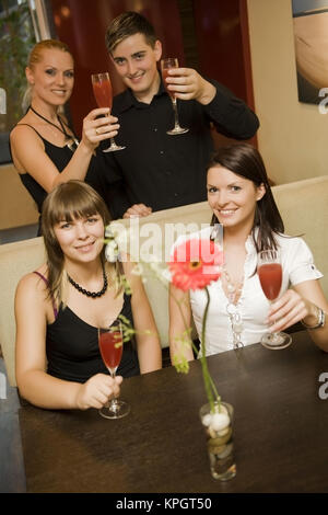 Model released , Vier junge Leute mit Erdbeerprosecco in einer Bar - young people with sparkling wine in a bar Stock Photo