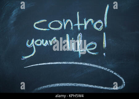 Motivate yourself. Control your life inscription on a blackboard written with colored chalks. Stock Photo