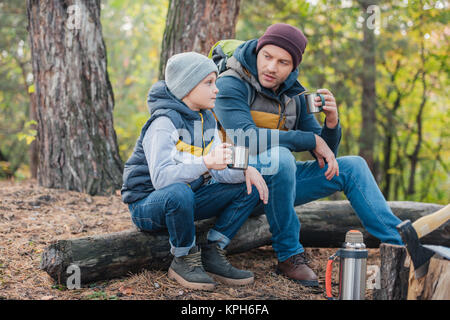 father and son drinking tea in forest Stock Photo