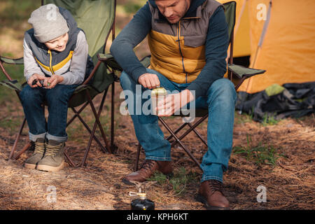 father and son eating in forest Stock Photo