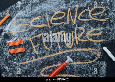 Science is a future inscription on a blackboard written with an orange chalk. Stock Photo