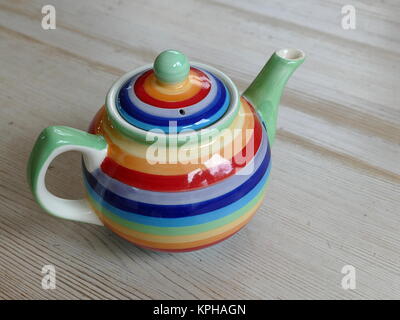 Colourful teapot on a wooden table Stock Photo
