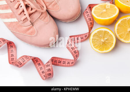 The old sneakers, a meter tape and lemon on an white Stock Photo