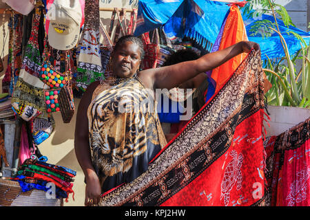 Local woman selling shawls and wraps at a stall with tourist souvenirs and clothing, Santa Maria, Sal Island, Salina, Cape Verde, Africa Stock Photo