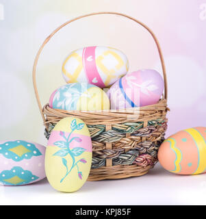 Painted Easter eggs and basket on a colorful background Stock Photo